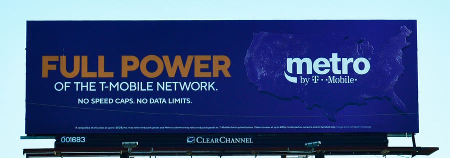 Clear Channel billboard advertising Metro by T-Mobile against a pale sky, with panel number 001683 under the ad.