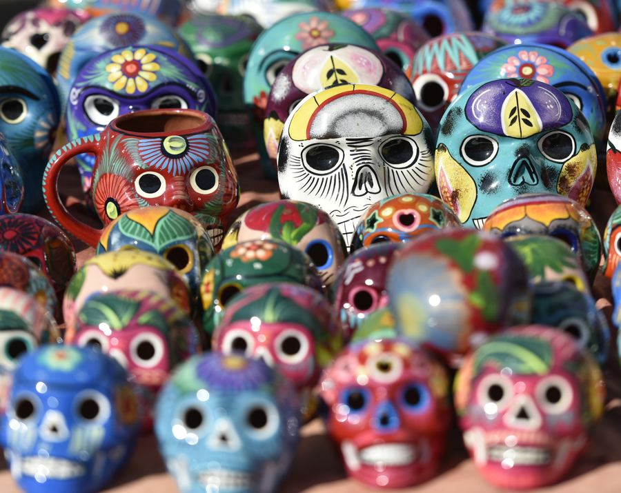 Rows of brightly painted ceramic sugar skulls for sale.